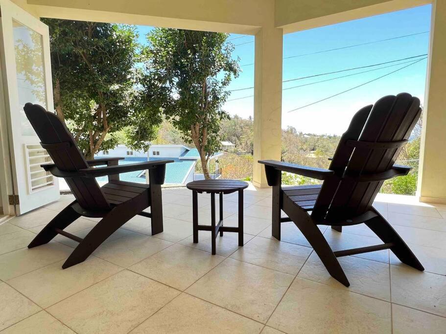 2 Stühle und ein Tisch auf der Terrasse in der Unterkunft Aruanda Apartment - perfect get-away for two at the top of Bequia in Union