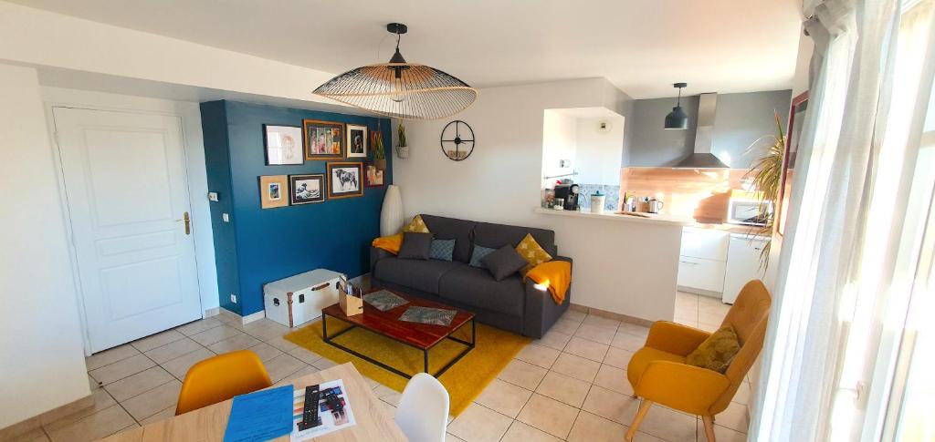 uma sala de estar com um sofá e uma mesa em Disneyland cosy Apartment em Montévrain