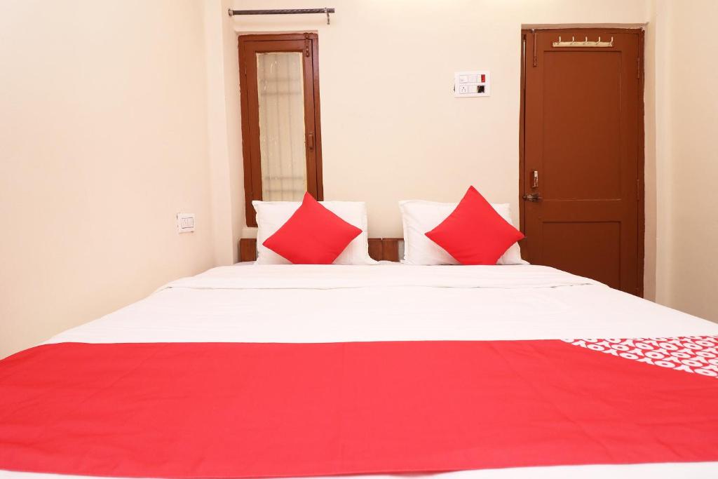 a bedroom with a large bed with red pillows at Flagship Hotel Midtown in Bhopal