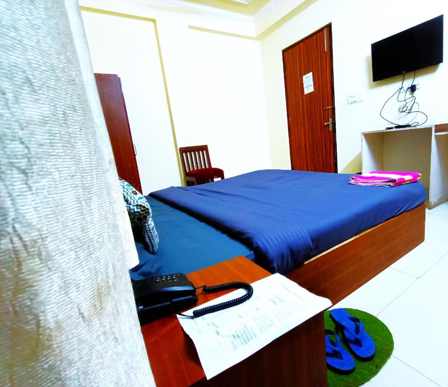 Hotel S-14 في جايبور: غرفة نوم بسرير ومكتب فيه تلفون