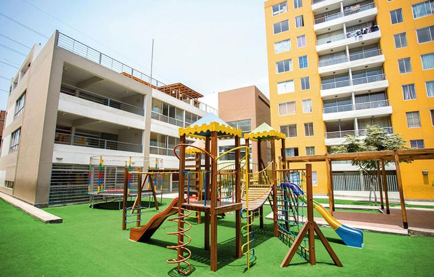um parque infantil em frente a um edifício em Bonito departamento VIP estreno en Condominio em Lima