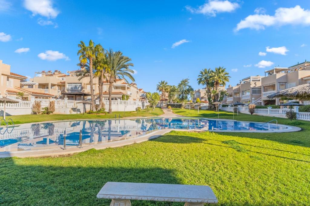 un parque con un banco frente a los apartamentos en condominio en Bugenwilla Orihuela Costa, en Orihuela Costa