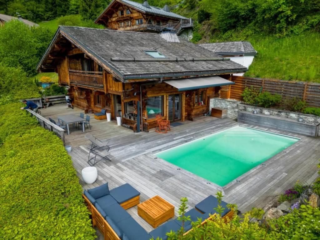 uma vista aérea de uma casa de madeira com uma piscina em Chalet Hygge avec piscine em Saint-Gervais-les-Bains