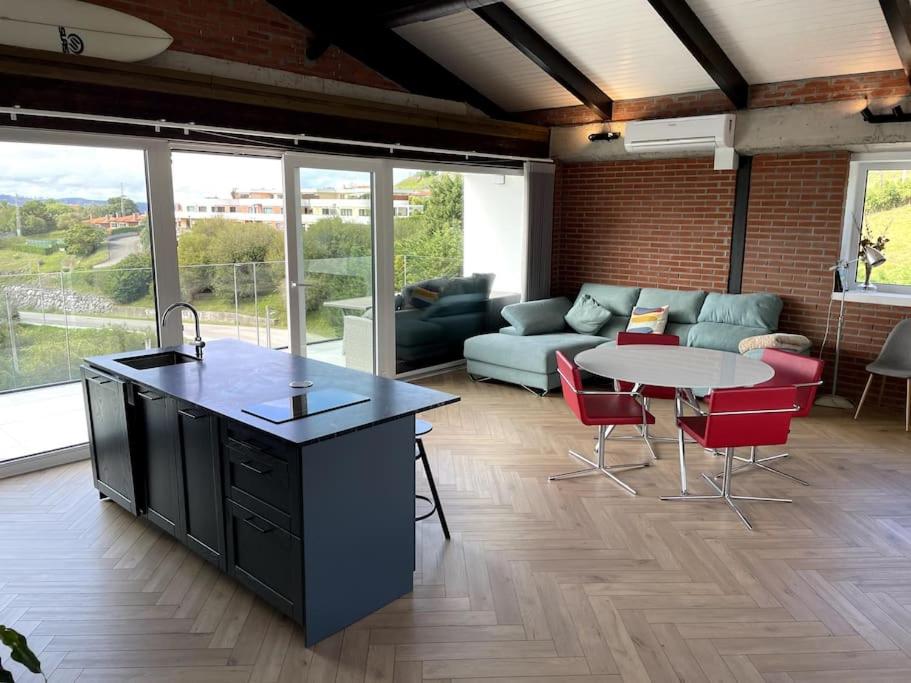 a kitchen and living room with a couch and a table at Casa Albuerne in Gijón
