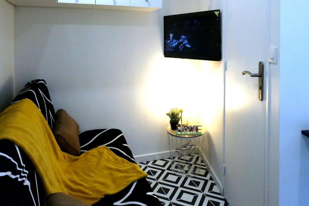 una persona acostada en una cama en una habitación en L’Impérial - HyperCentre - WIFI, en Étampes