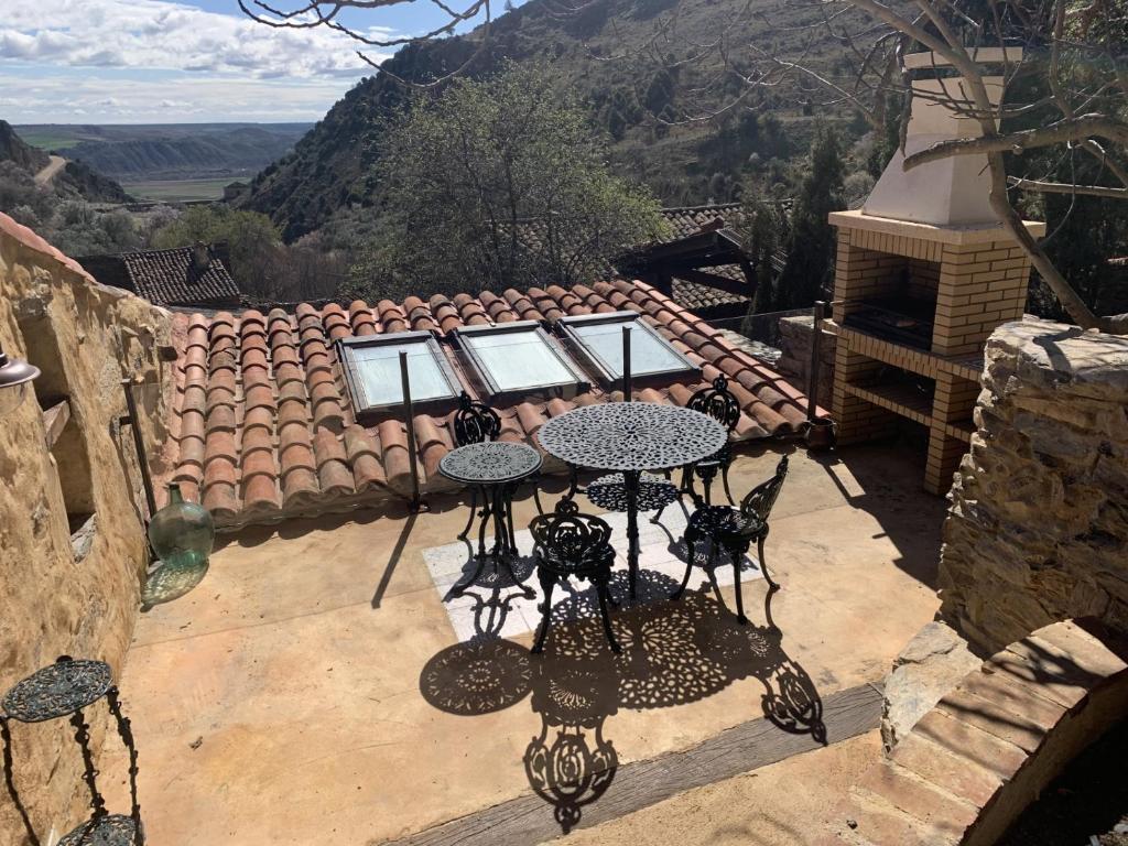 a patio with two tables and a view of a mountain at Patones de Arriba in Patones