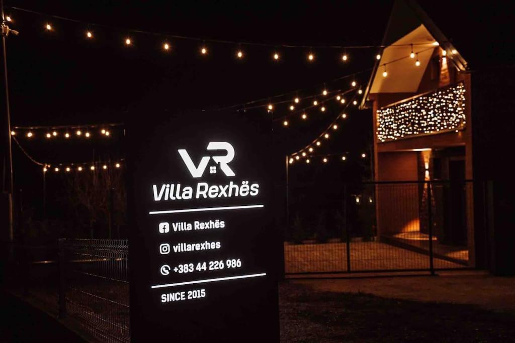 a sign in front of a building with lights at Villa Rexhes in Ferizaj
