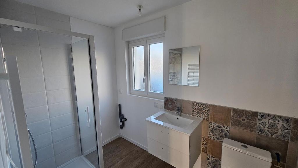 uma casa de banho branca com um lavatório e um chuveiro em Nid douillet en Suisse Normande em Thury-Harcourt