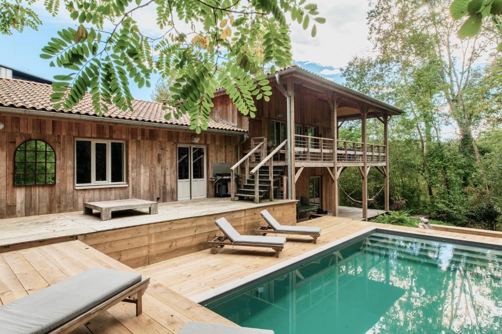 une maison avec piscine à côté d'une maison dans l'établissement La Cabane du Moulin, à Saubion