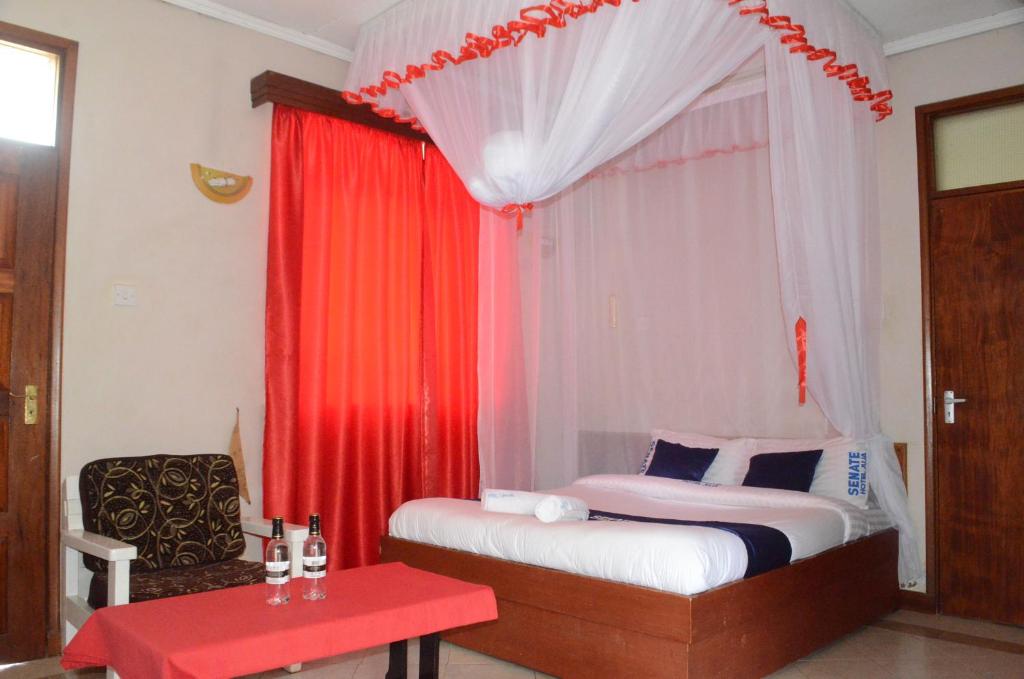 1 dormitorio con cama y cortina roja en HOTEL SENATE JUJA en Thika