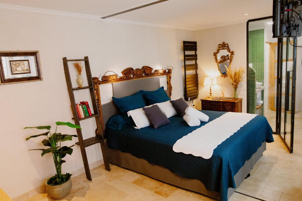 a bedroom with a bed with blue and white pillows at Suite de Diane - Premiere conciergerie in Nîmes