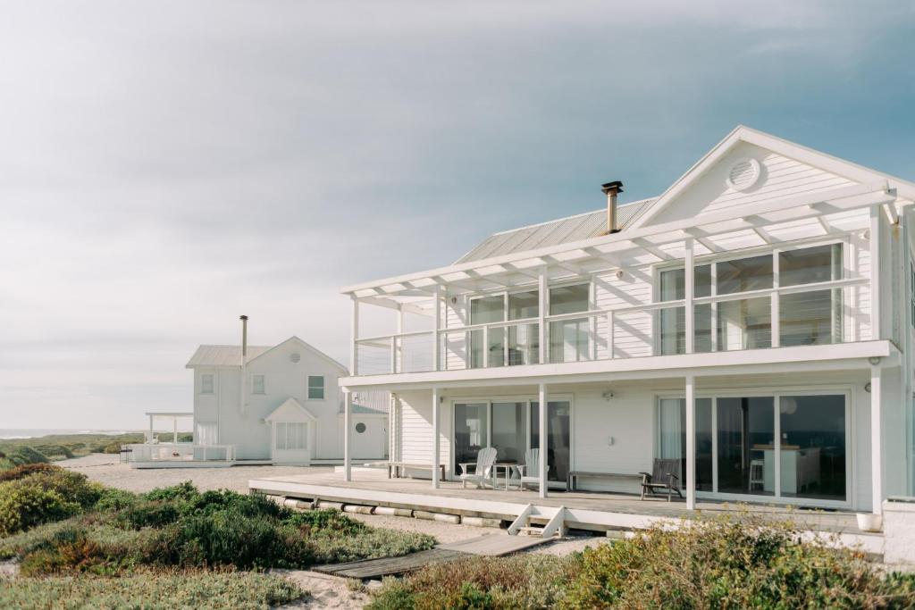 a white house with a lot of windows at White Sands Beach Villa in Yzerfontein