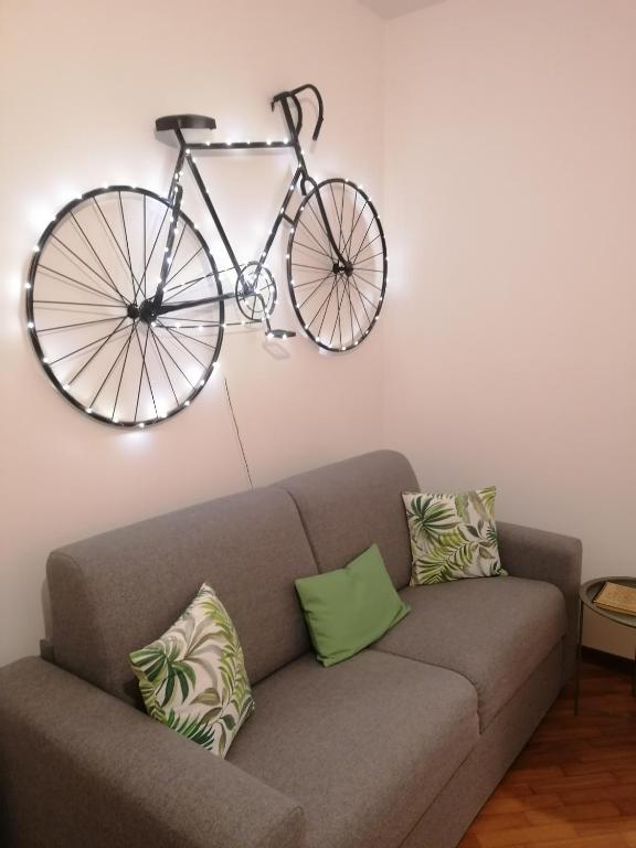 a bike hanging on a wall above a couch at amaRE in Reggio Emilia
