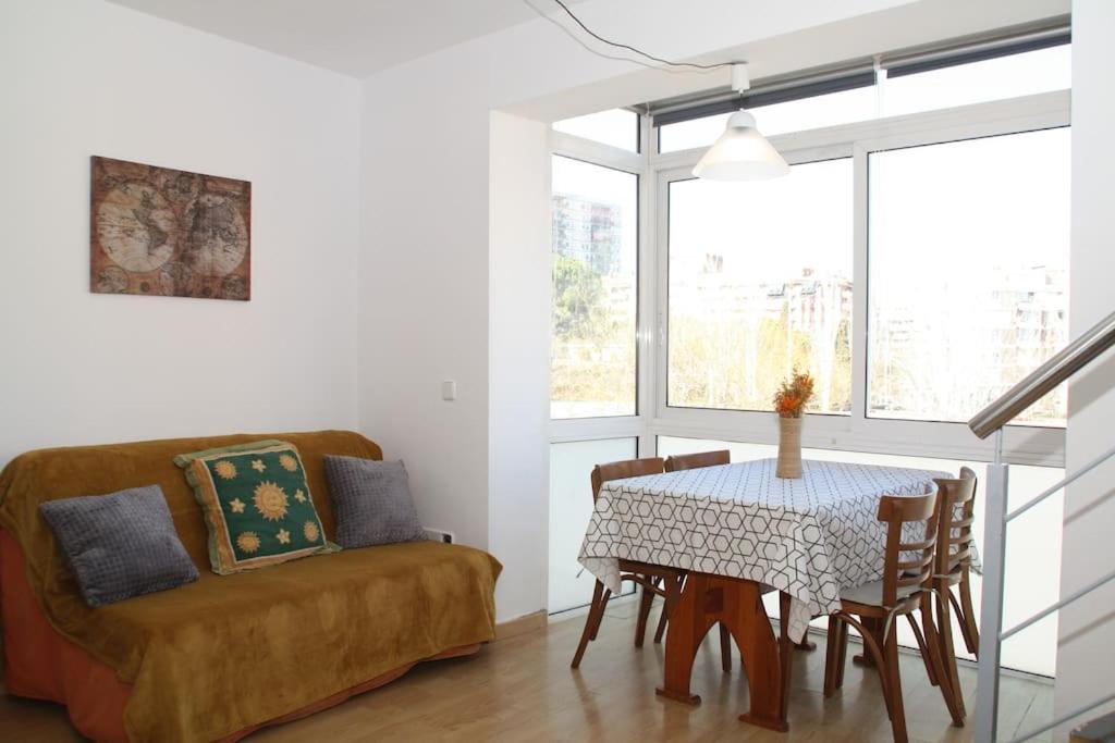 a dining room with a table and a couch at My Home in Igualada in Igualada