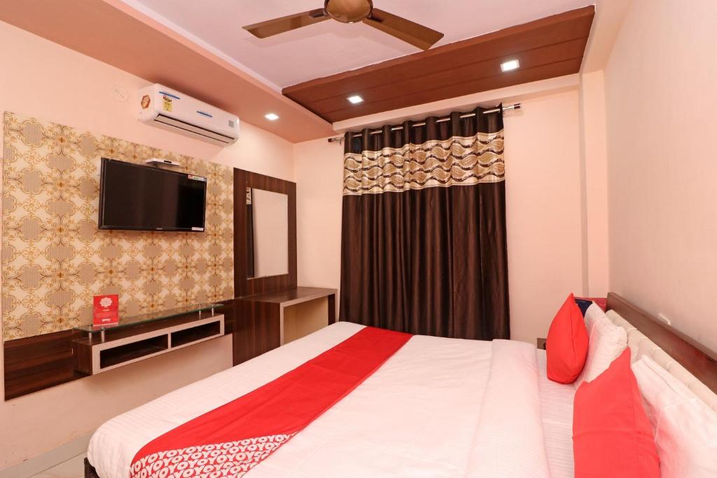 1 dormitorio con 1 cama y TV de pantalla plana en Flagship Hotel Royal Paradise en Tīrath