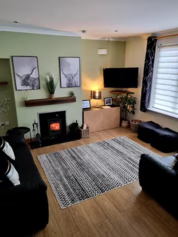 a living room with a couch and a fireplace at 3 Treig Road in Fort William