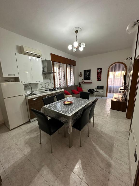 Appartamento Annesca - Delta del Po في بورتو تولي: مطبخ وغرفة معيشة مع طاولة وكراسي