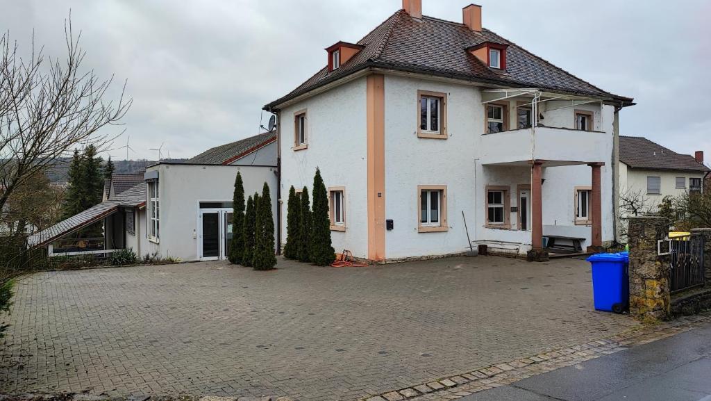 a large white house with a driveway in front of it at Monteurwohnung bis 6 Personen mit 4 gratis Parklätzen und Grill und WLAN 3x Schlafzimmer in Veitshöchheim