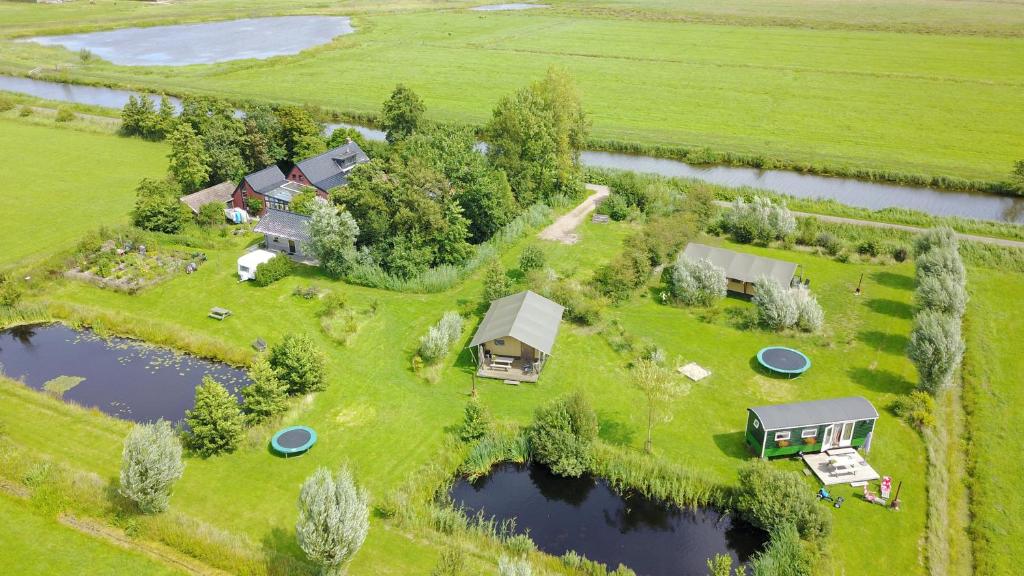 an aerial view of a farm with a group of houses and water at Safaritent Lisdodde in Lettelbert