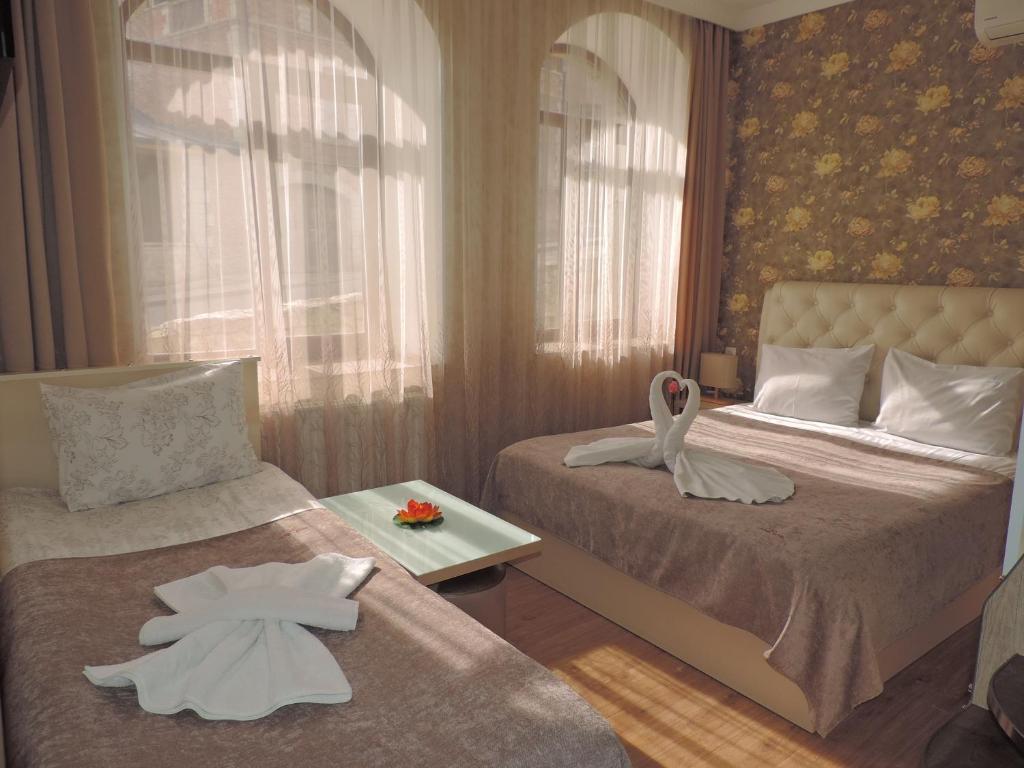 1 dormitorio con 2 camas y toallas blancas. en Hotel Lotus, en Akhaltsikhe