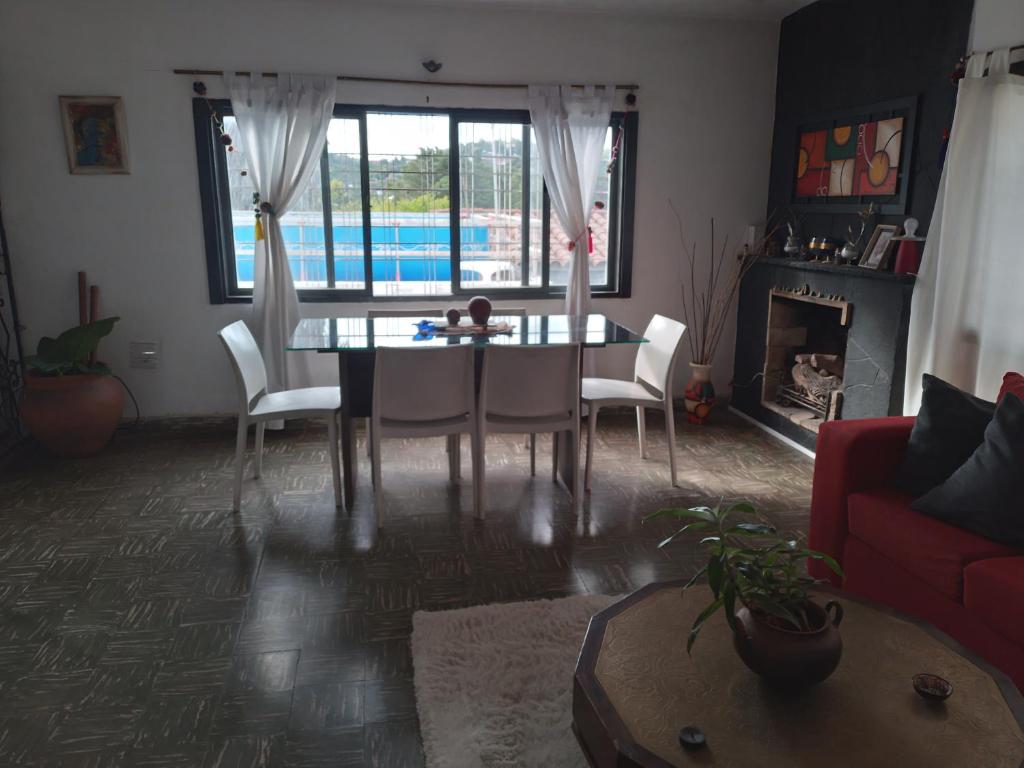 a living room with a table and chairs and a pool at Alquiler temporario villa Carlos Paz in Villa Carlos Paz