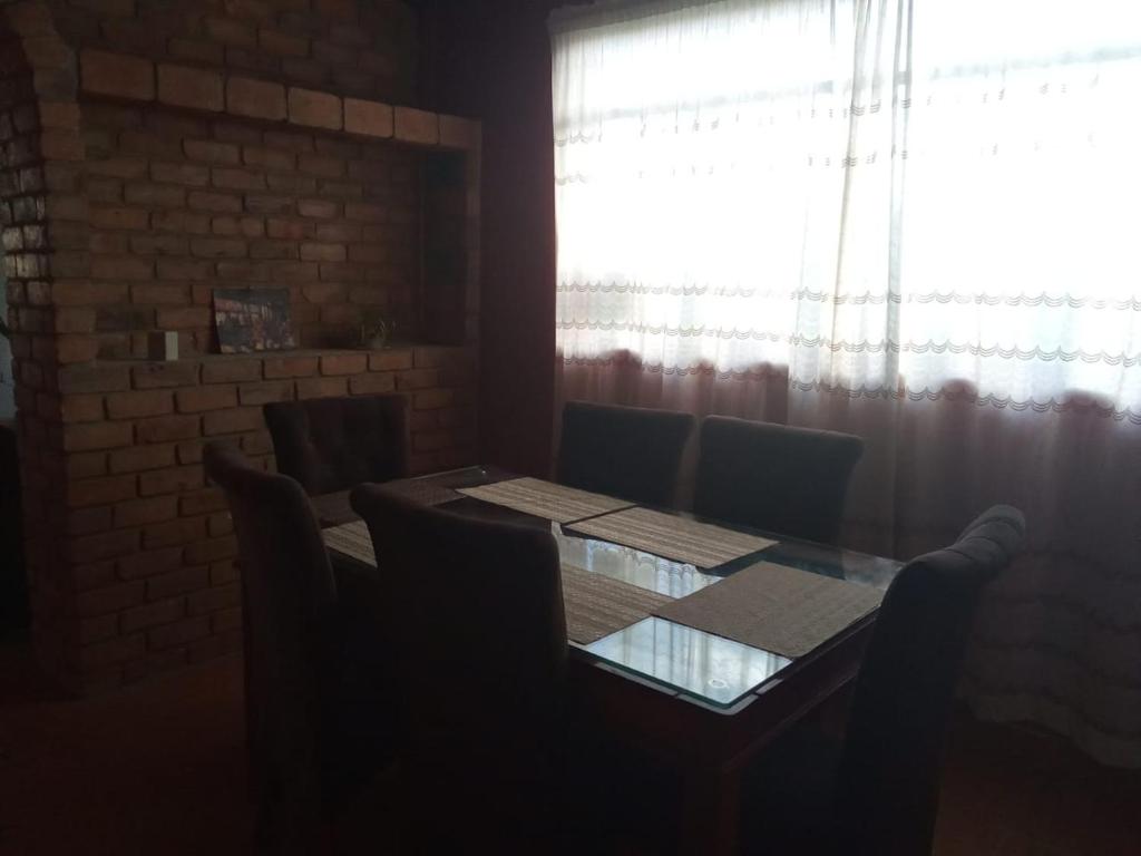 a dining room table with chairs and a window at El amanecer in Cajamarca
