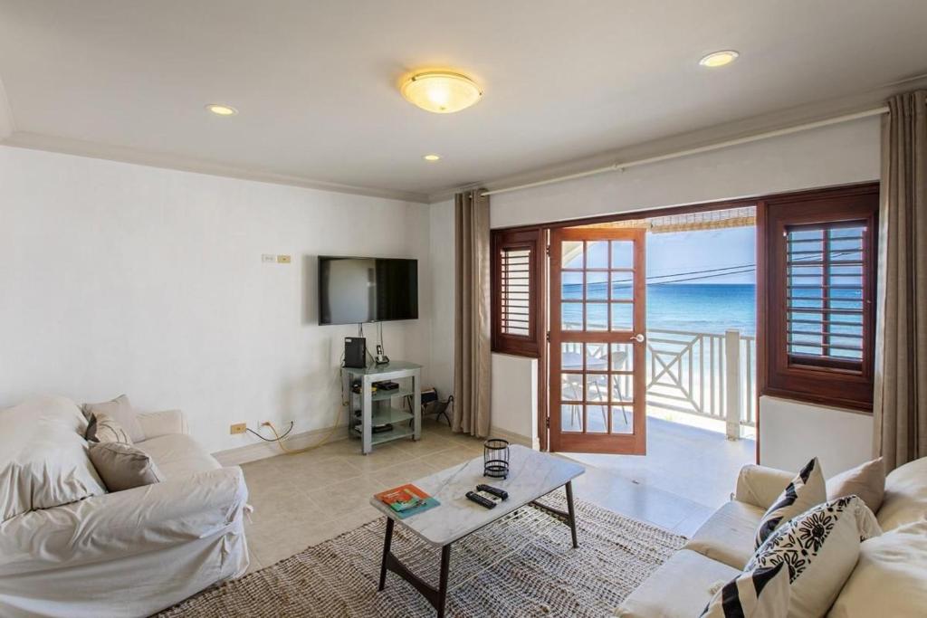 Whitesands G4 by Barbados Sothebys International Realty في سانت بيتير: غرفة معيشة مع أريكة بيضاء وطاولة