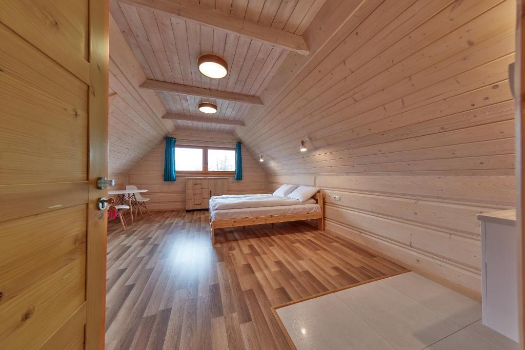 um quarto com uma cama num chalé de madeira em Zajazd Śleboda em Ząb