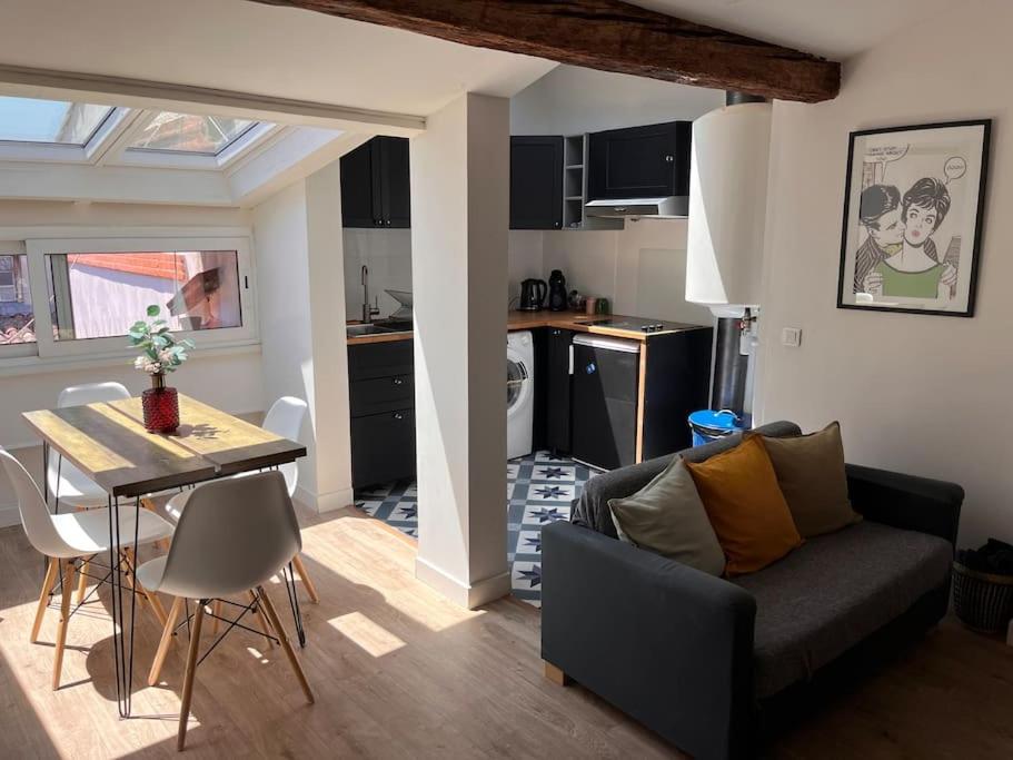 un salon et une cuisine avec un canapé et une table dans l'établissement Charmant T2 au coeur de Toulouse quartier Carmes/Esquirol, à Toulouse