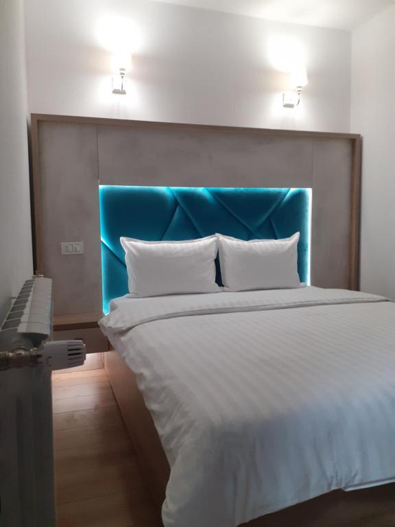 ラク・ロシュにあるPensiunea Stefaniaのベッドルーム1室(大型ベッド1台、青いヘッドボード付)