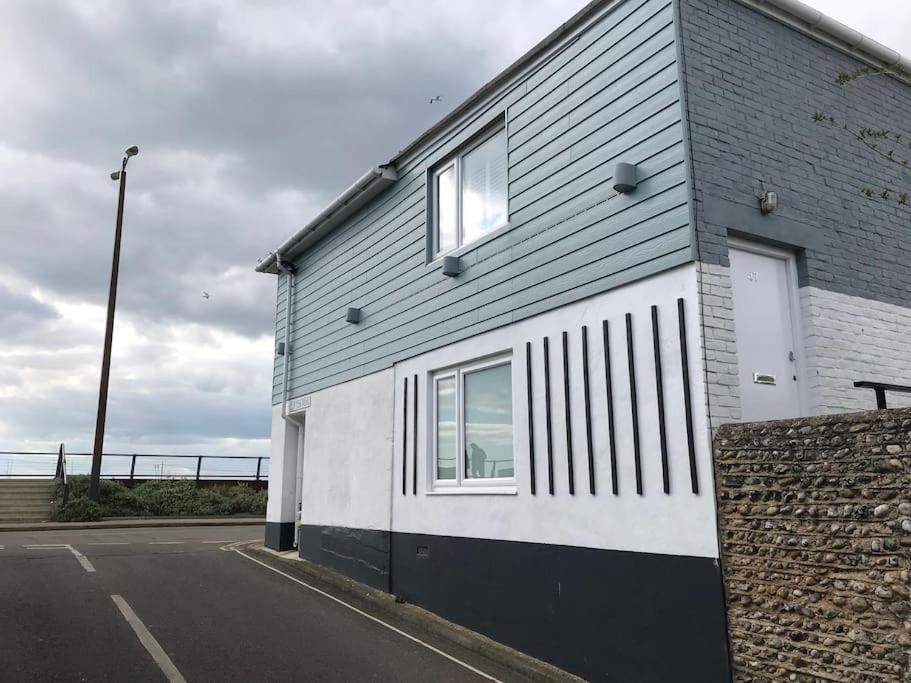 a gray and white building with a window at Riverside Seaside Apartment in Littlehampton