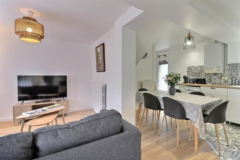 uma sala de estar com um sofá e uma mesa em La Dolce Vita, jolie maison familiale em Troyes