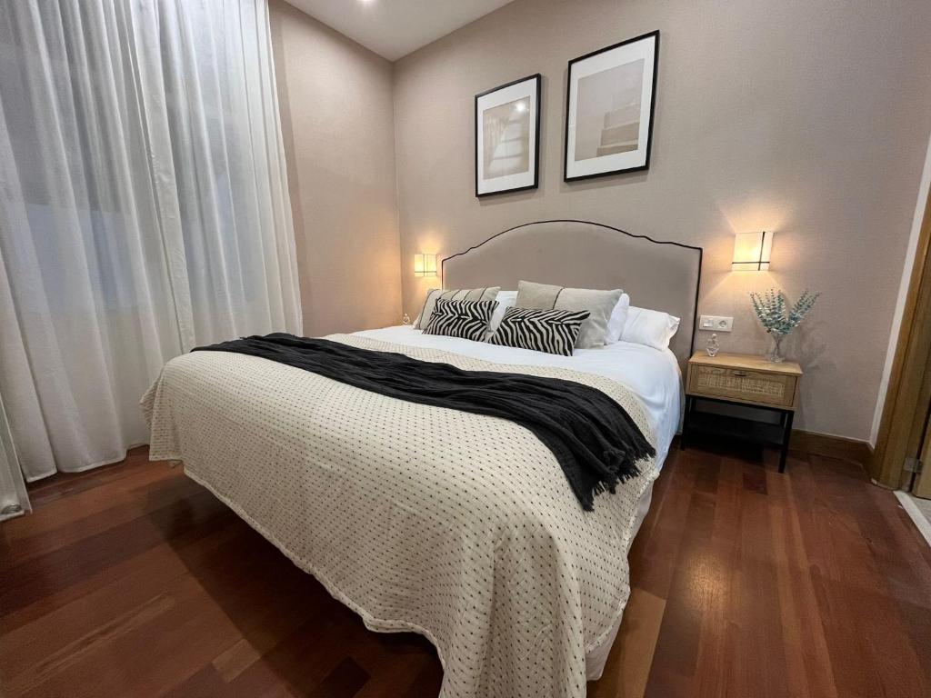 ein Schlafzimmer mit einem großen weißen Bett mit zwei Kissen in der Unterkunft Old Town Core next to Plaza Nueva in Bilbao