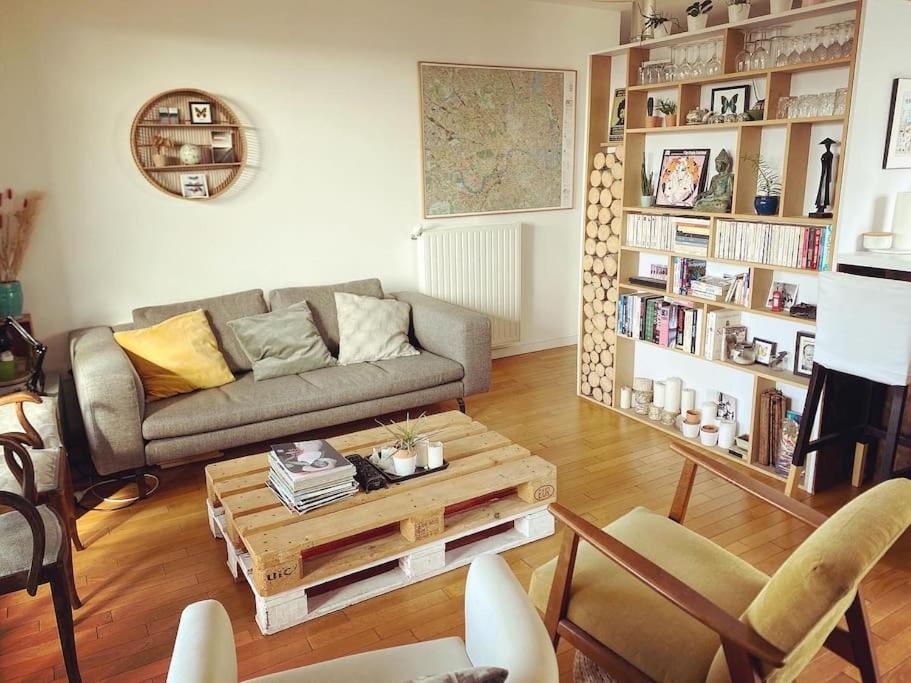 un salon avec un canapé et une table basse dans l'établissement Appartement idéal JO à 10 min de Paris (metro 14), à Saint-Ouen