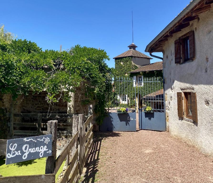 un edificio con una valla y una puerta con una señal en La Grange, en Coutouvre