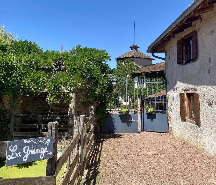 a building with a fence and a gate with a sign at La Grange in Coutouvre