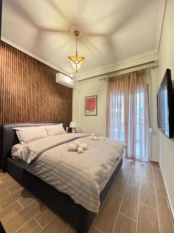 een slaapkamer met een groot bed met twee knuffels erop bij KOI Apartment Toumba SKG in Thessaloniki