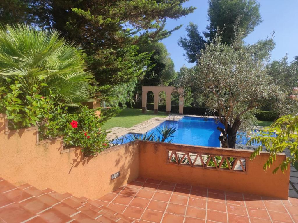 une piscine dans une arrière-cour avec des arbres et une clôture dans l'établissement El Carrascal, La Sella Golf, à Muntanya la Sella