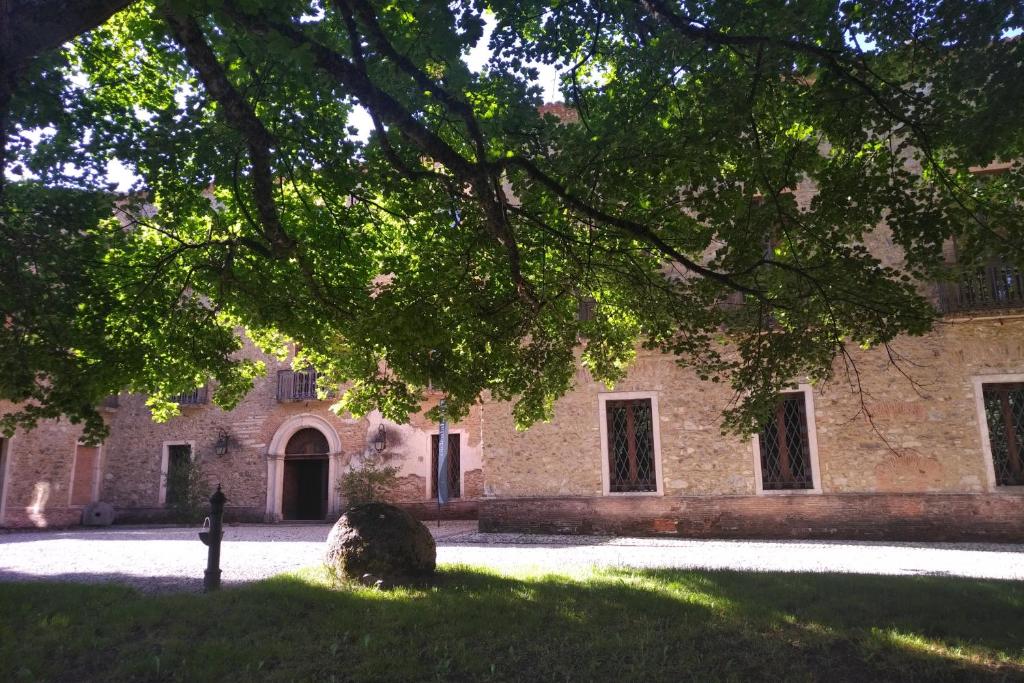 un edificio de ladrillo con un árbol delante de él en Torre Camigliati Dimora Storica, en Camigliatello Silano