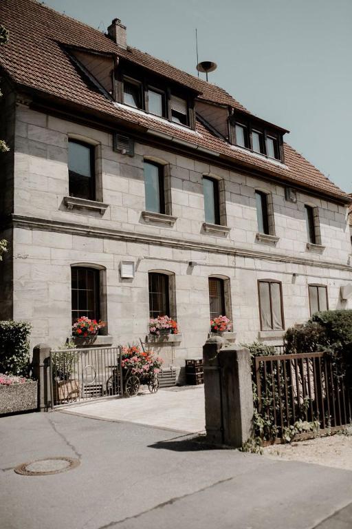 a large stone building with flowers in the windows at Gasthaus Rotes Ross in Eckental
