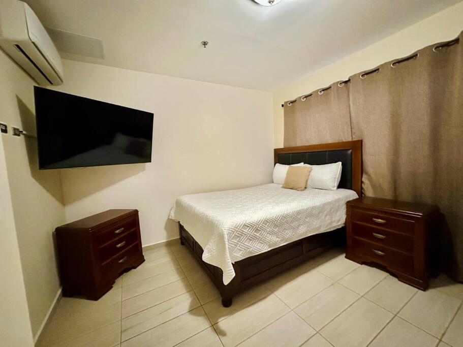 um quarto com uma cama e uma televisão de ecrã plano em 3BR Apartment in Acacias San Ignacio em Tegucigalpa