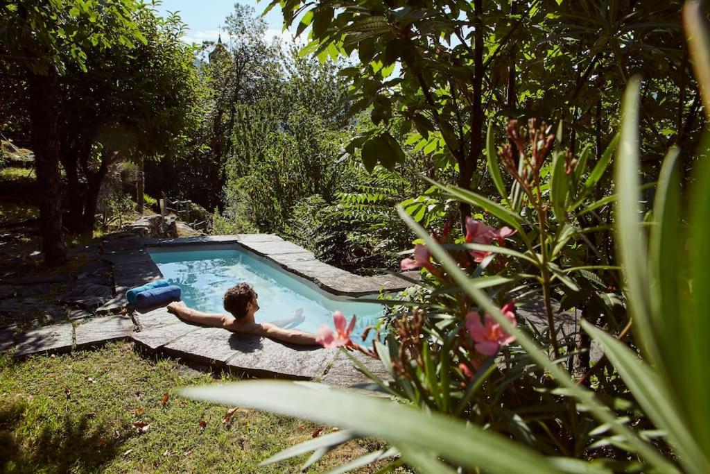 a boy in a swimming pool in a garden at Wild Valley Rustico Style in Valle Onsernone in Auressio