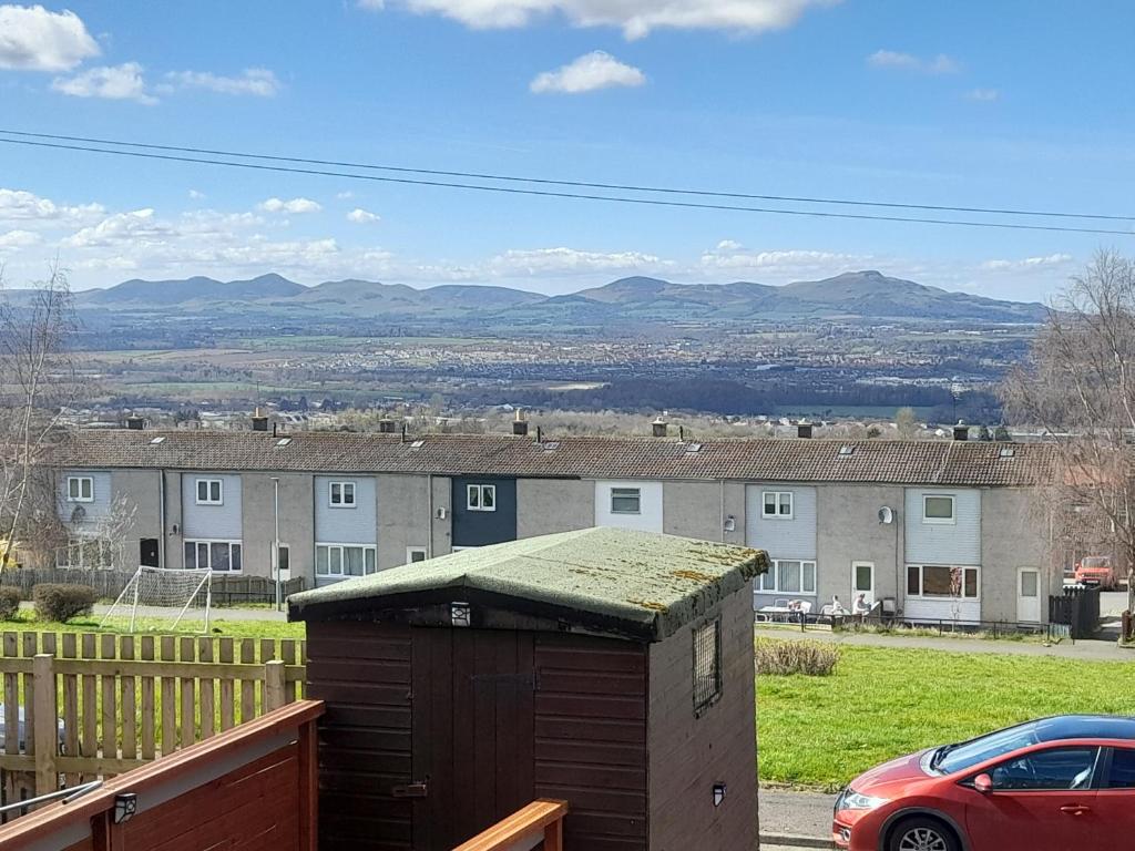 a small out house with a car parked in a yard at Bastolino in Newtongrange