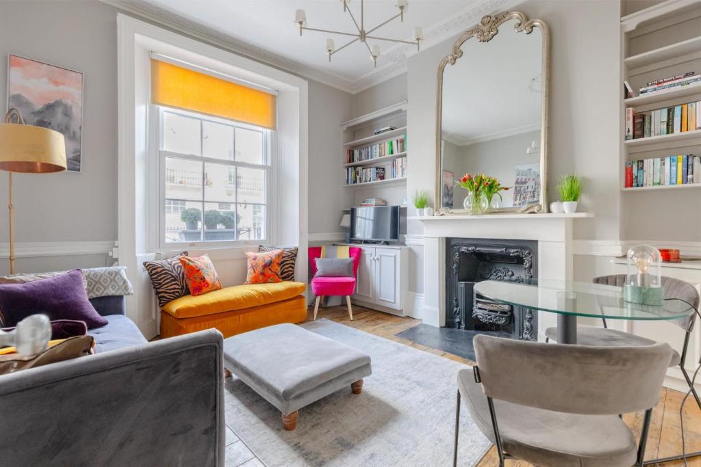 a living room with a table and a fireplace at Vogue 1 bedroom Pimlico flat near Victoria Station in London