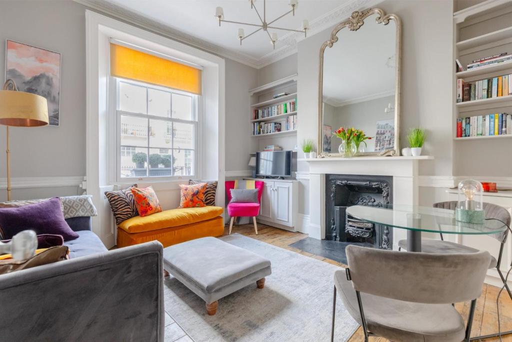 ロンドンにあるVogue 1 bedroom Pimlico flat near Victoria Stationのリビングルーム(テーブル、暖炉付)