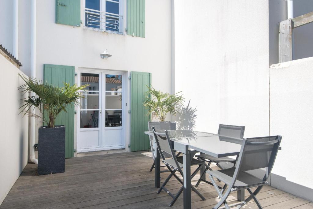 a patio with a table and chairs on a deck at Appartement Valène in La Flotte