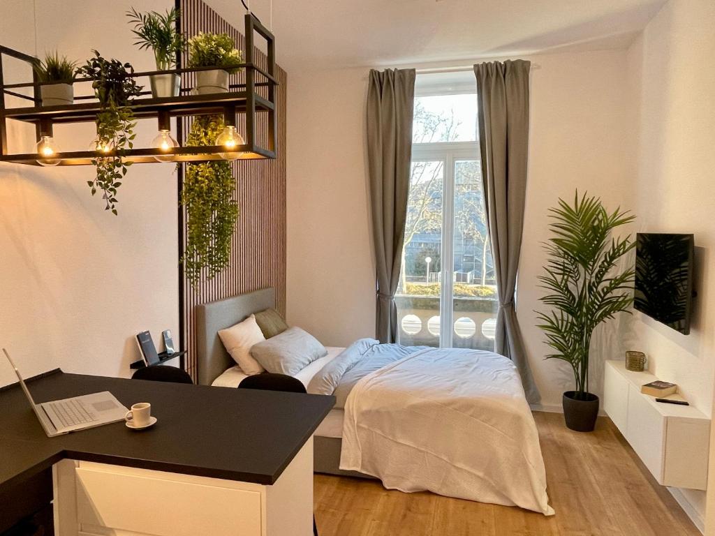 1 dormitorio con cama, escritorio y ventana en Modernes Apartment im Zentrum von Karlsruhe, en Karlsruhe