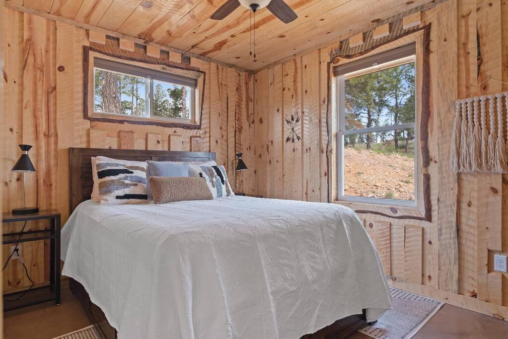 - une chambre avec un lit dans une cabane en bois dans l'établissement Sun Filled Joy BHBungalows #8, à Custer
