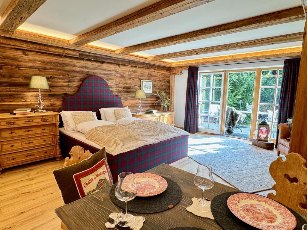 a bedroom with a bed and a table with wine glasses at Mountain Suites by Belle-Stay in Kitzbühel