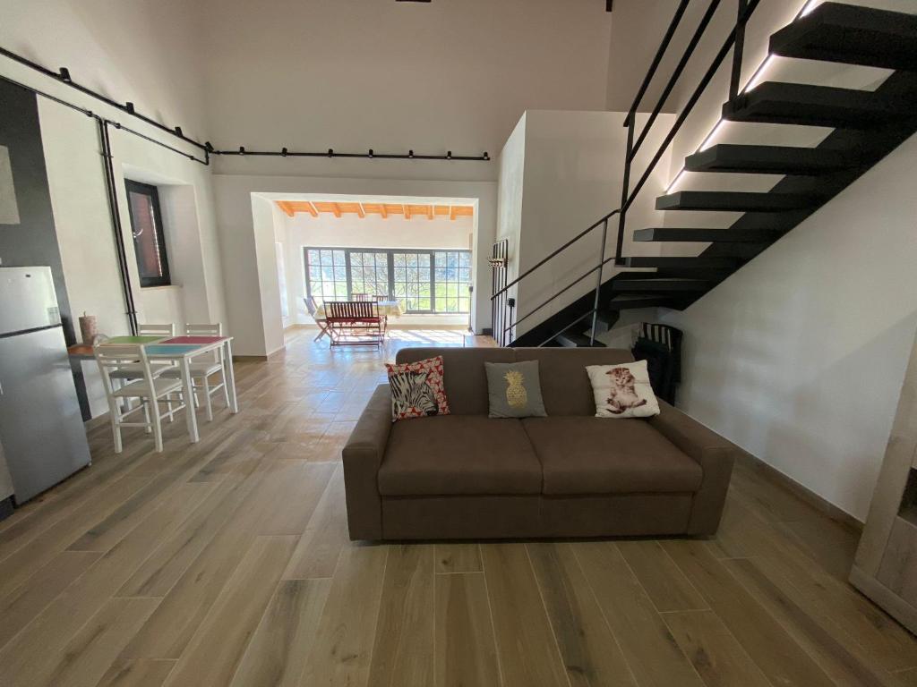 uma sala de estar com um sofá e uma escada em Emerald Apartment em Valmontone